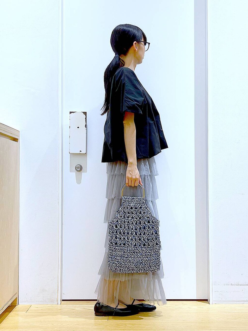 ブラック系のTシャツ/カットソー、ブラック系のパンプス、ブルー系のハンドバッグを着用したレディースの春コーディネートの4枚目の写真