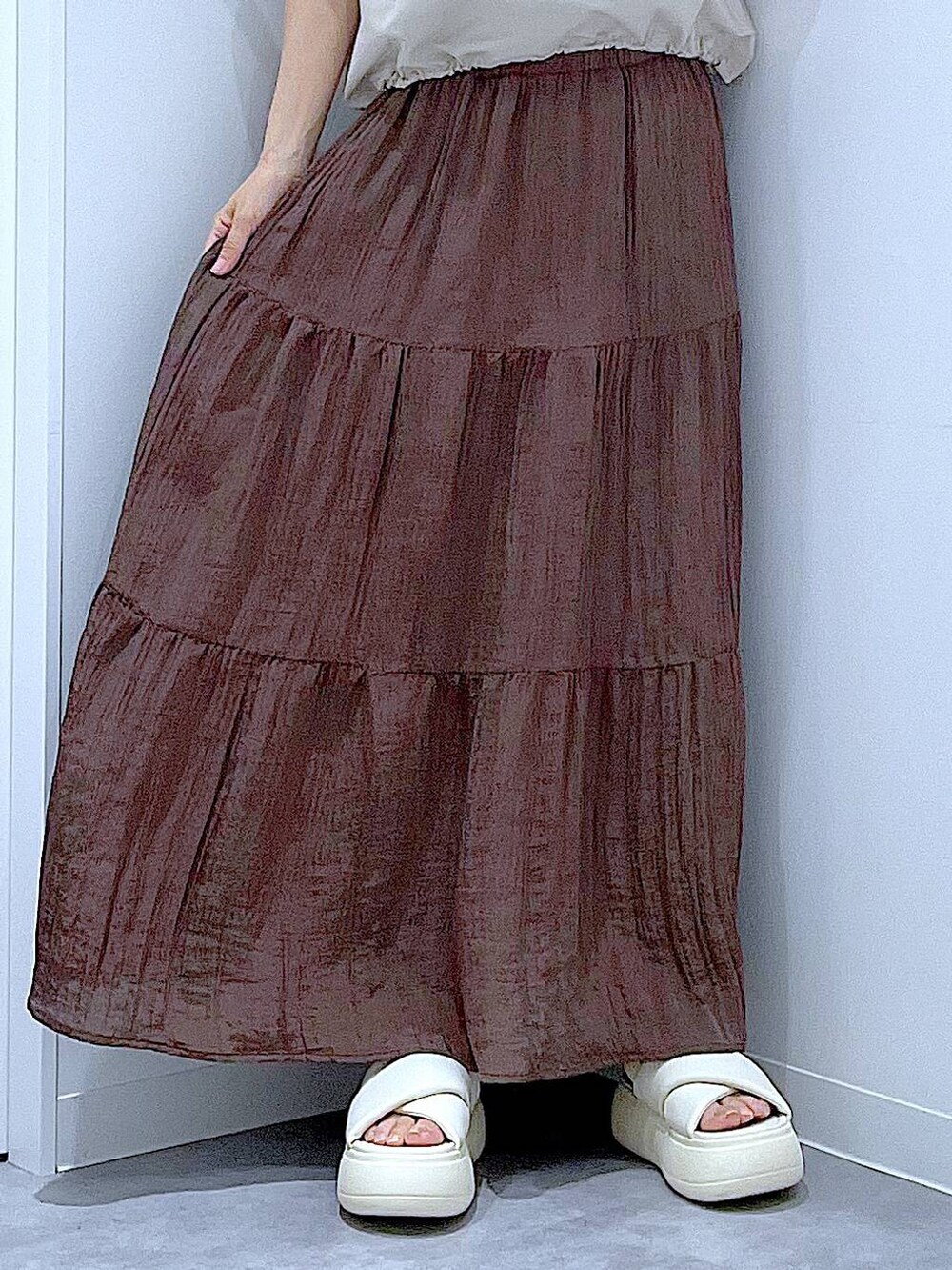 ブラック系のショルダーバッグ、ホワイト系のサンダル、ベージュ系のTシャツ/カットソーを着用したレディースの夏コーディネートの8枚目の写真