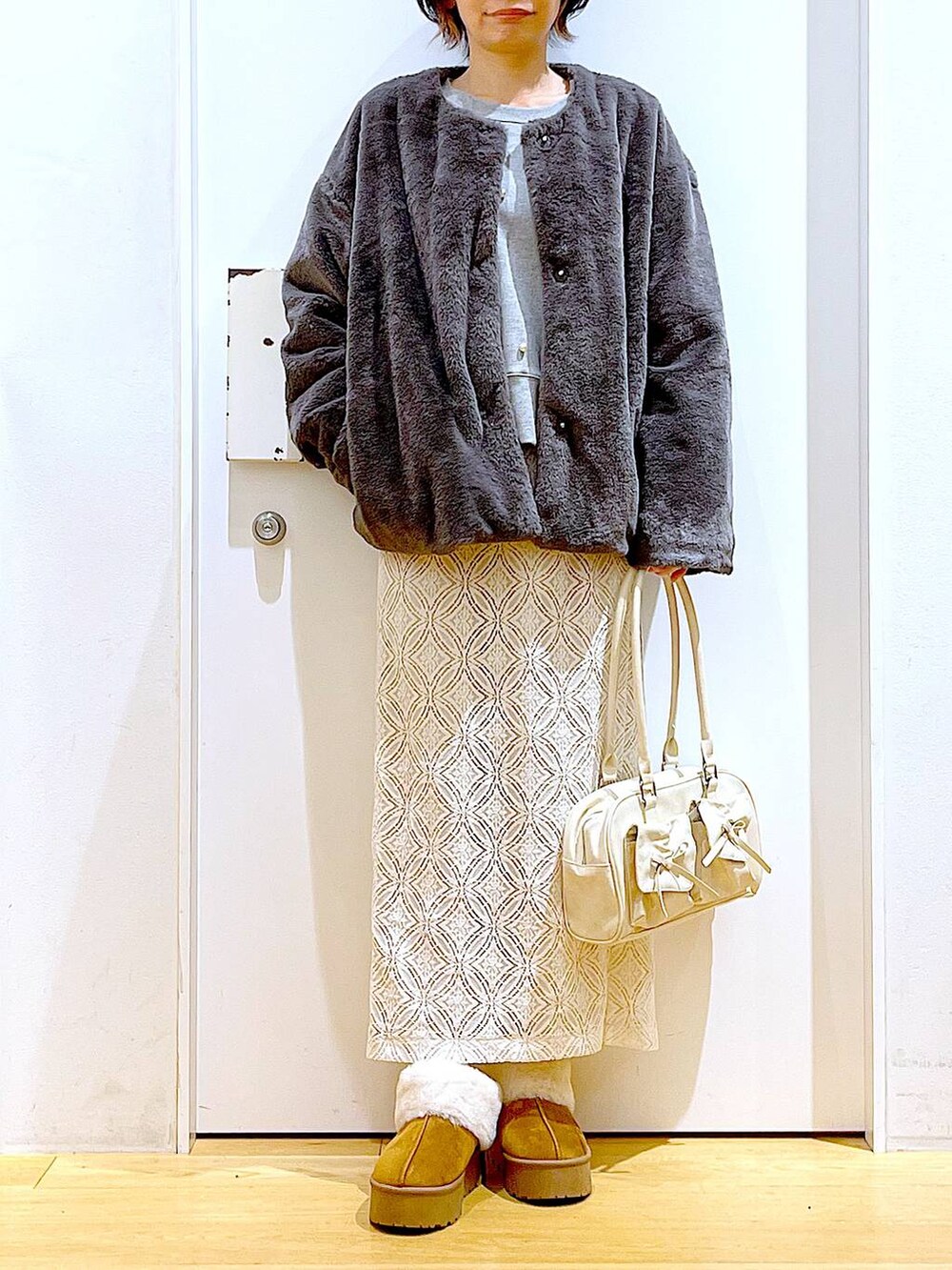 ベージュ系のスリッポン、ホワイト系のハンドバッグ、グレー系のスウェットを着用したレディースの秋コーディネートの6枚目の写真