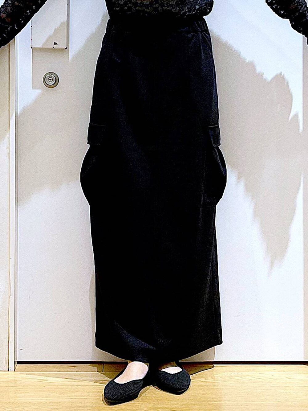 ブラック系のショルダーバッグ、ブラック系のパンプス、ブラック系のスカートを着用したレディースの春コーディネートの8枚目の写真