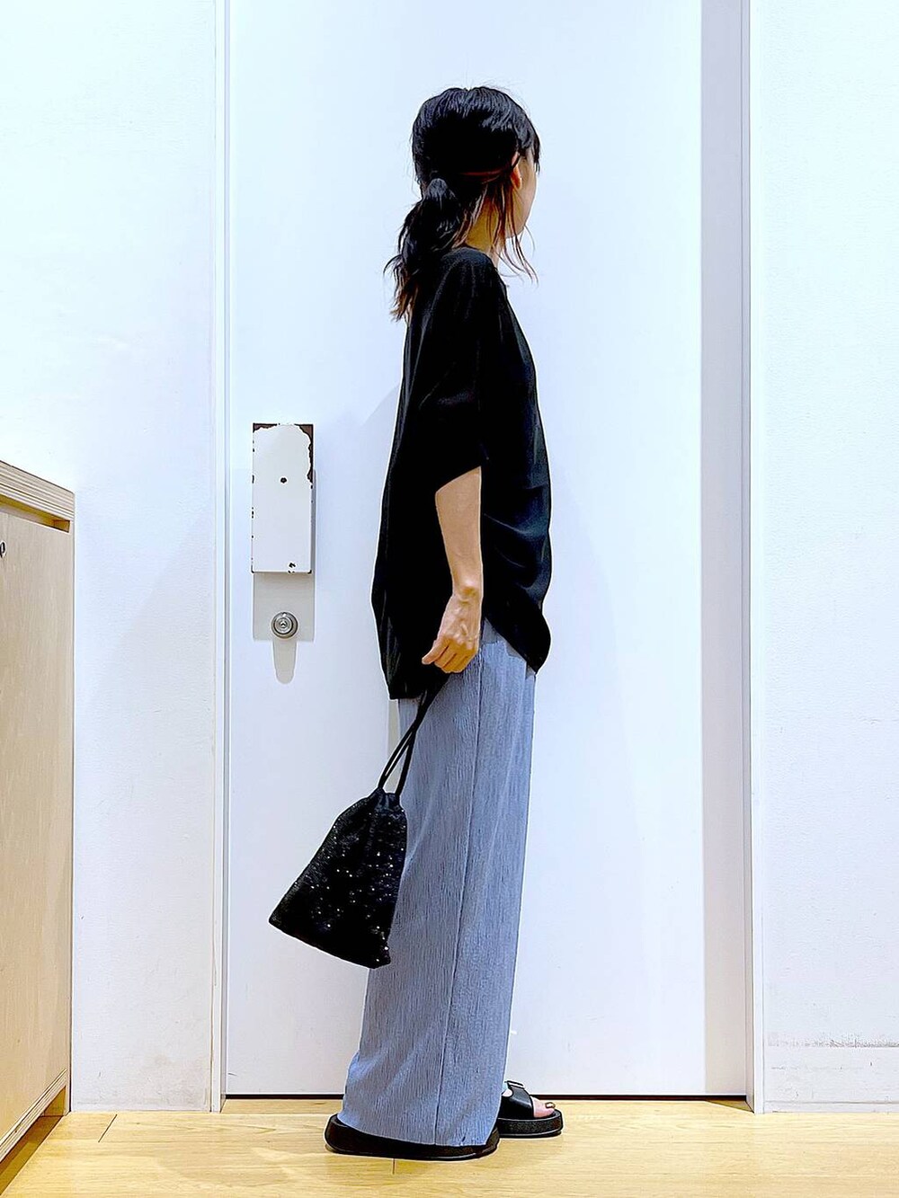 ブラック系のサンダル、ブルー系のその他パンツ、ブラック系のショルダーバッグを着用したレディースの夏コーディネートの4枚目の写真