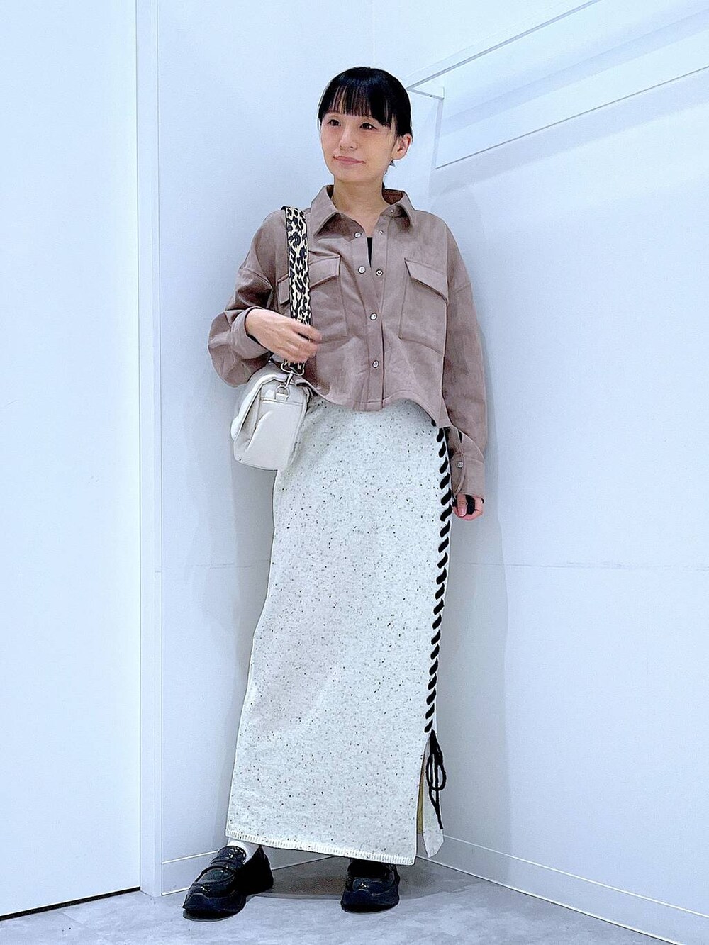 ブラック系のローファー、ホワイト系のショルダーバッグ、ブラウン系のシャツ/ブラウスを着用したレディースの秋コーディネートの2枚目の写真