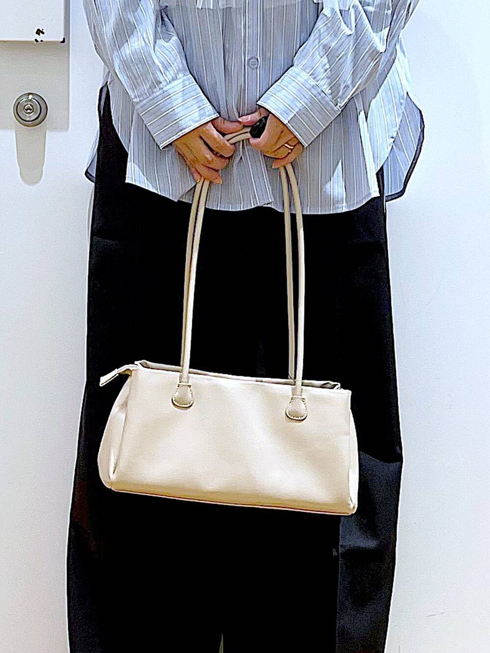 ブラック系のスラックス、ホワイト系のトートバッグ、ブラック系のパンプスを着用したレディースの春コーディネートの8枚目の写真