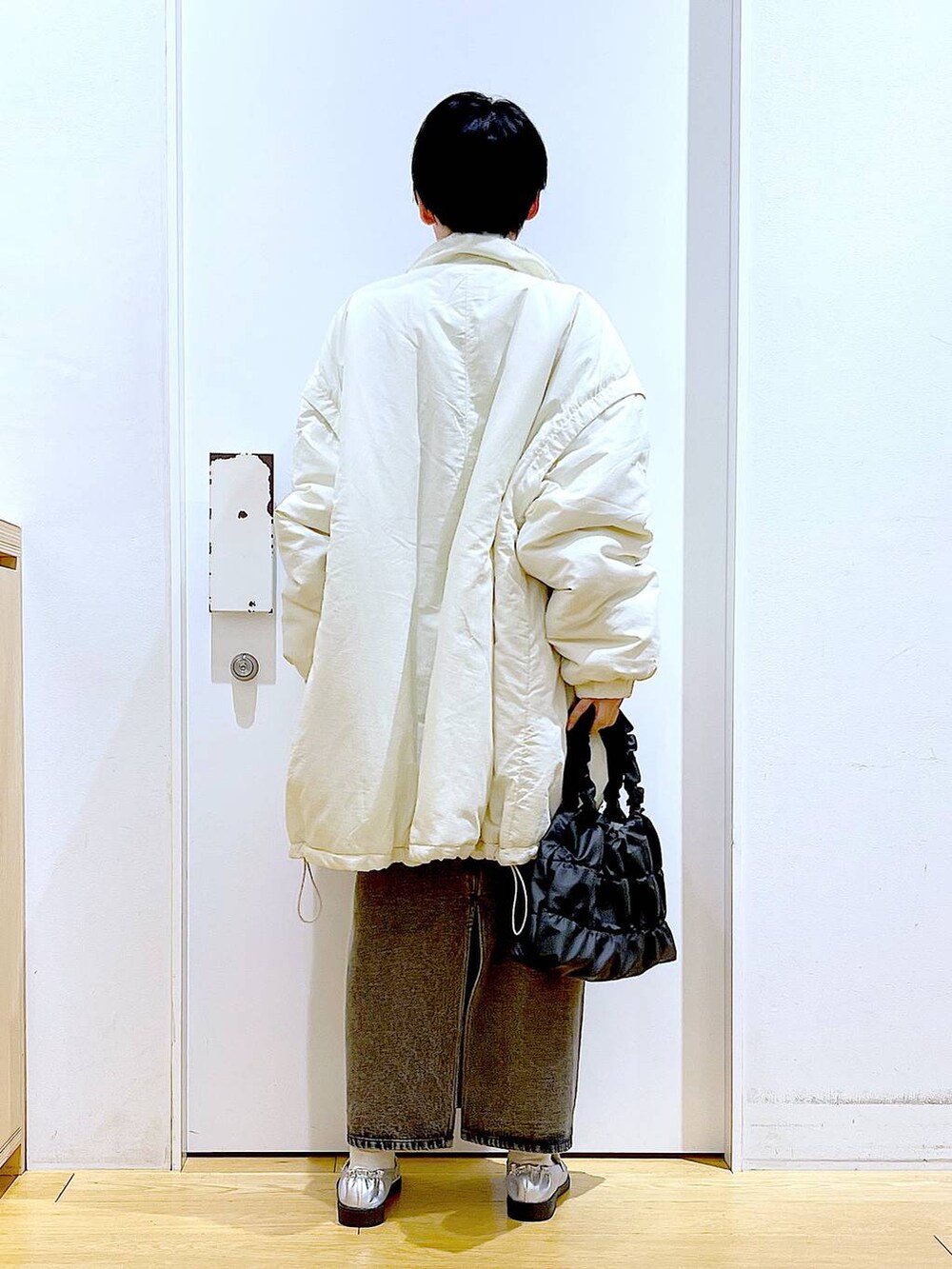 シルバー系のローファー、ホワイト系のその他アウター、ブラック系のショルダーバッグを着用したレディースの冬コーディネートの5枚目の写真