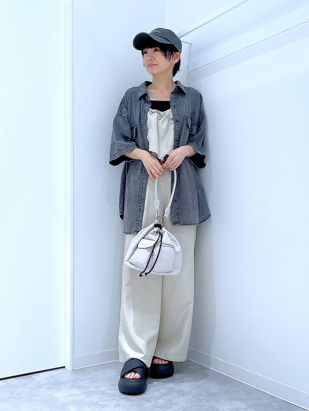 ブラック系のサンダル、グレー系のショルダーバッグ、ブラック系のシャツ/ブラウスを着用したレディースの夏コーディネートの2枚目の写真