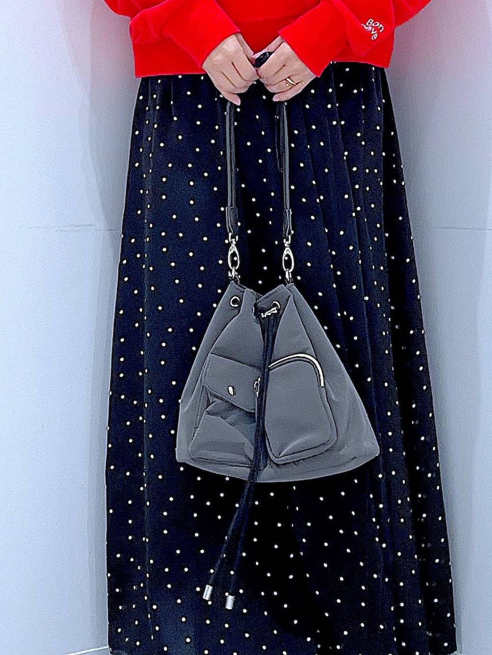 レッド系のスウェット、グレー系のシュシュを着用したレディースの春コーディネートの9枚目の写真