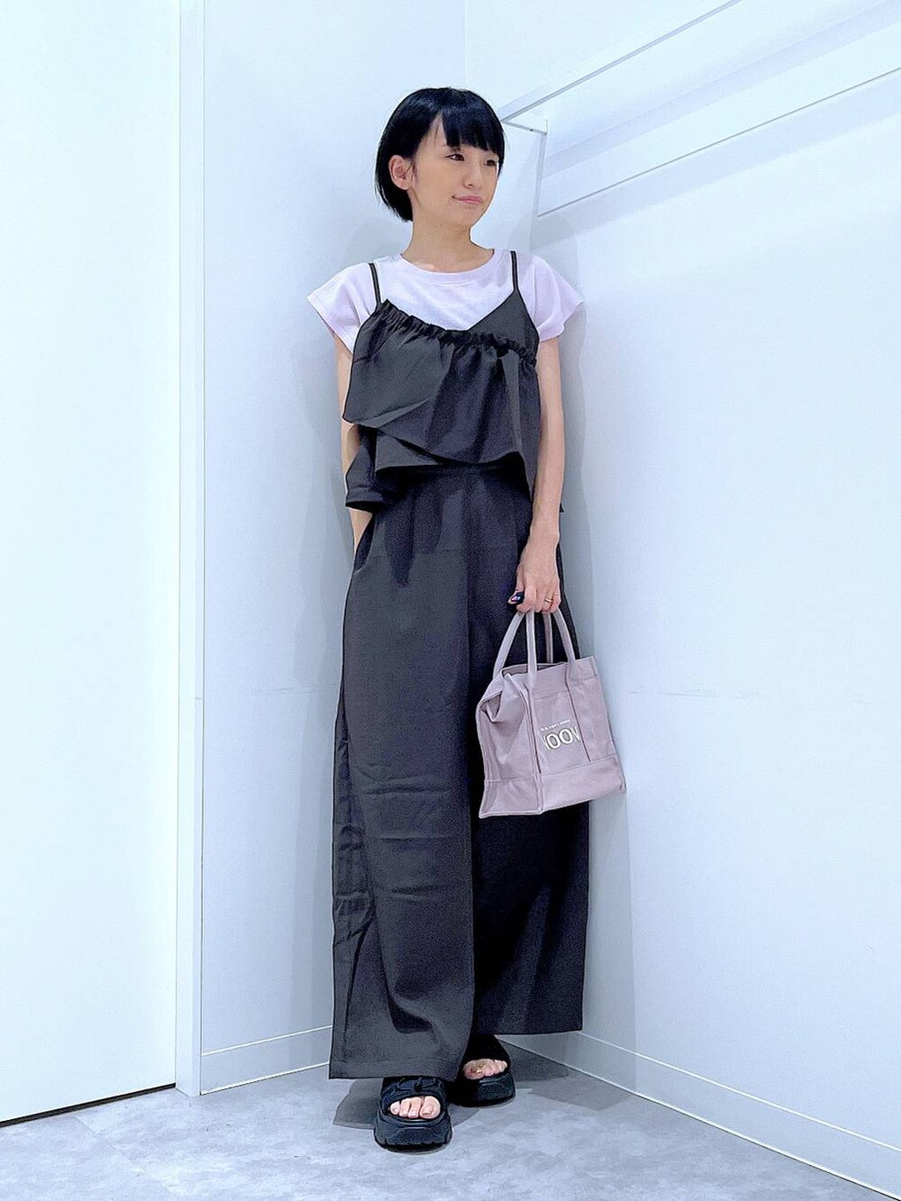 ブラック系のスニーカー、ブラック系のつなぎ/オールインワン、パープル系のTシャツ/カットソーを着用したレディースの秋コーディネートの2枚目の写真