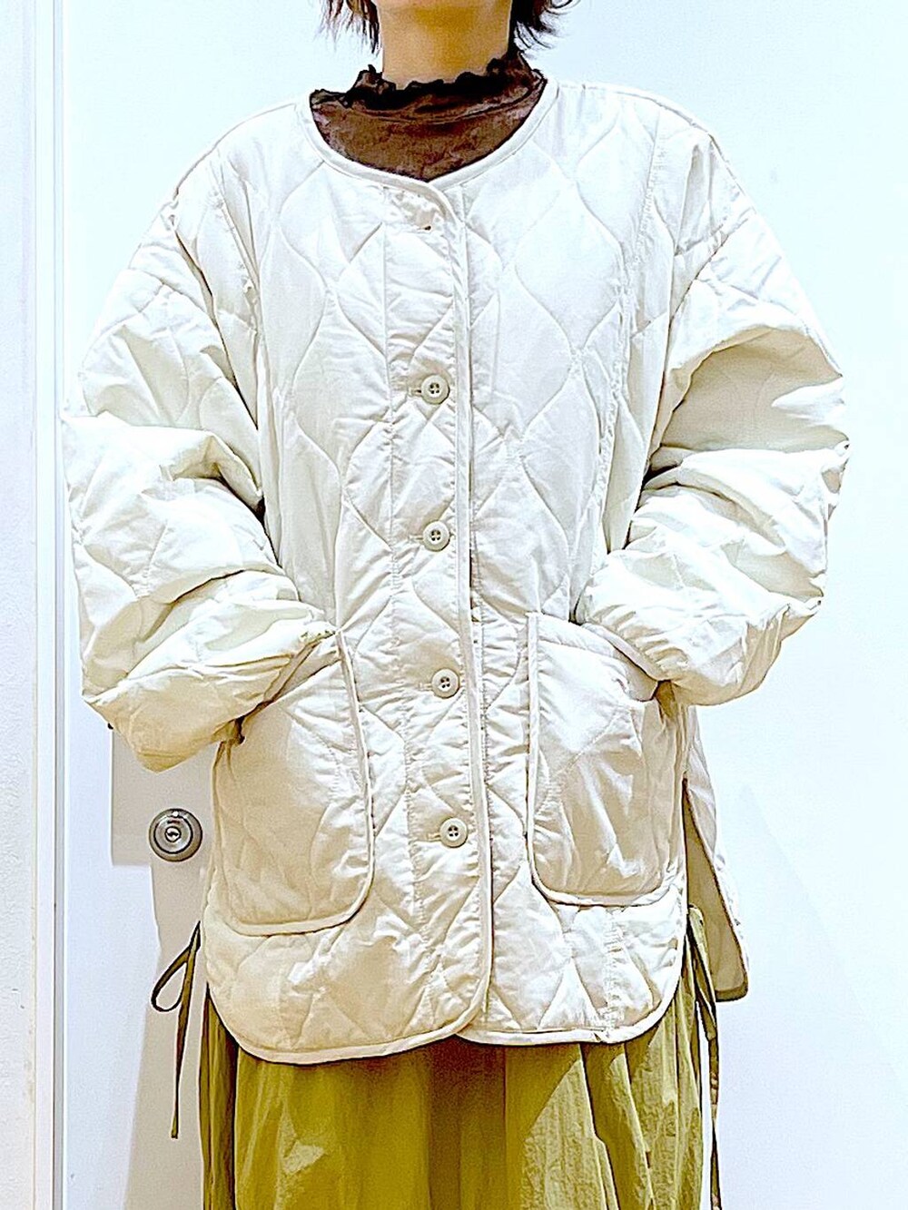 ベージュ系のブルゾン、ベージュ系のスリッポン、ホワイト系のハンドバッグを着用したレディースの秋コーディネートの7枚目の写真