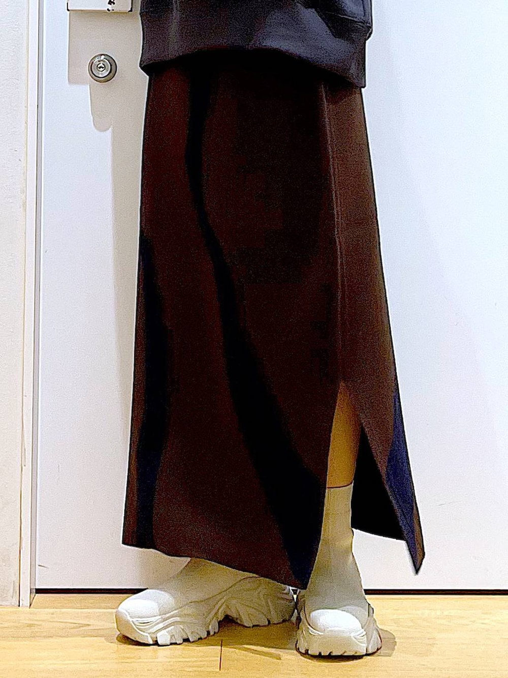 ブラウン系のスカート、グレー系のショルダーバッグ、ベージュ系のブーツを着用したレディースの冬コーディネートの8枚目の写真