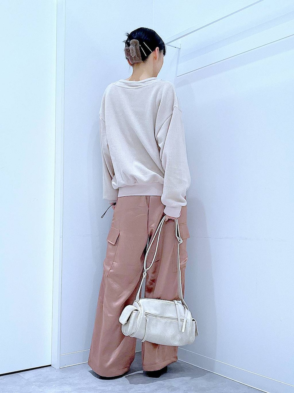 ブラック系のブーツ、ベージュ系のニット/セーター、ピンク系のカーゴパンツを着用したレディースの冬コーディネートの5枚目の写真