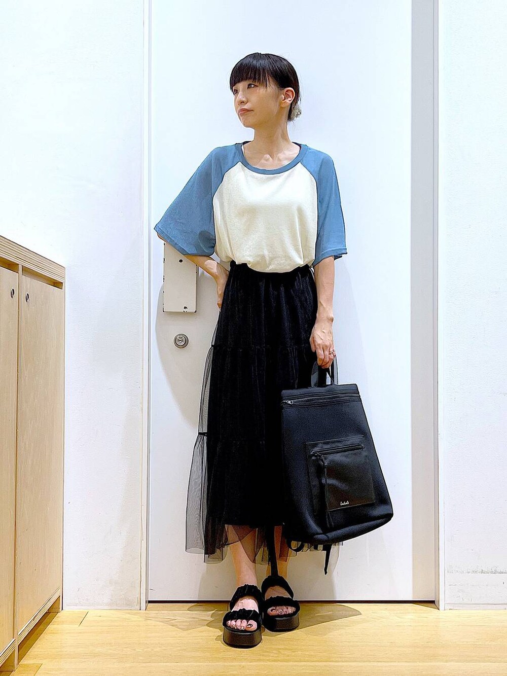 ブラック系のサンダル、ブルー系のTシャツ/カットソー、ブラック系のスカートを着用したレディースの夏コーディネートの2枚目の写真