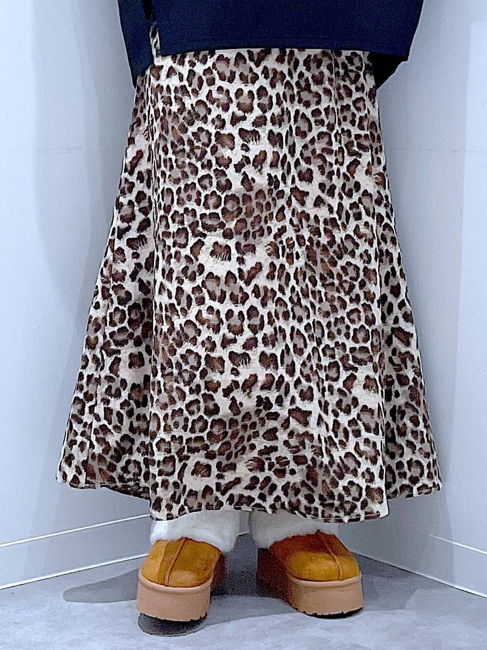 イエロー系のスリッポン、ベージュ系のハンドバッグ、ブラウン系のスカートを着用したレディースの秋コーディネートの8枚目の写真