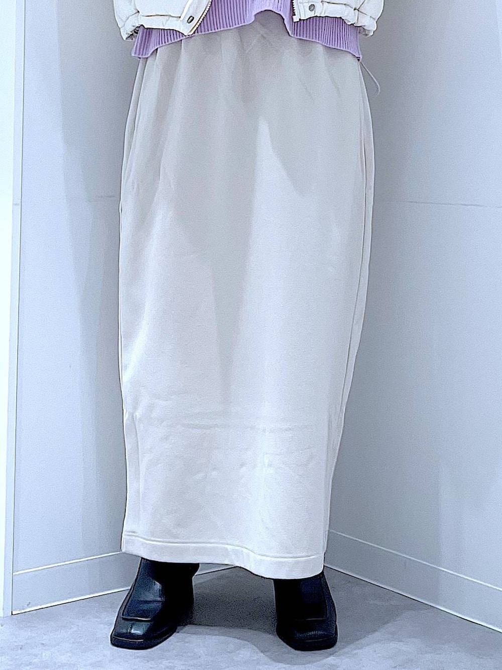 ホワイト系のブルゾン、ベージュ系のスカート、ブラック系のブーツを着用したレディースの冬コーディネートの8枚目の写真