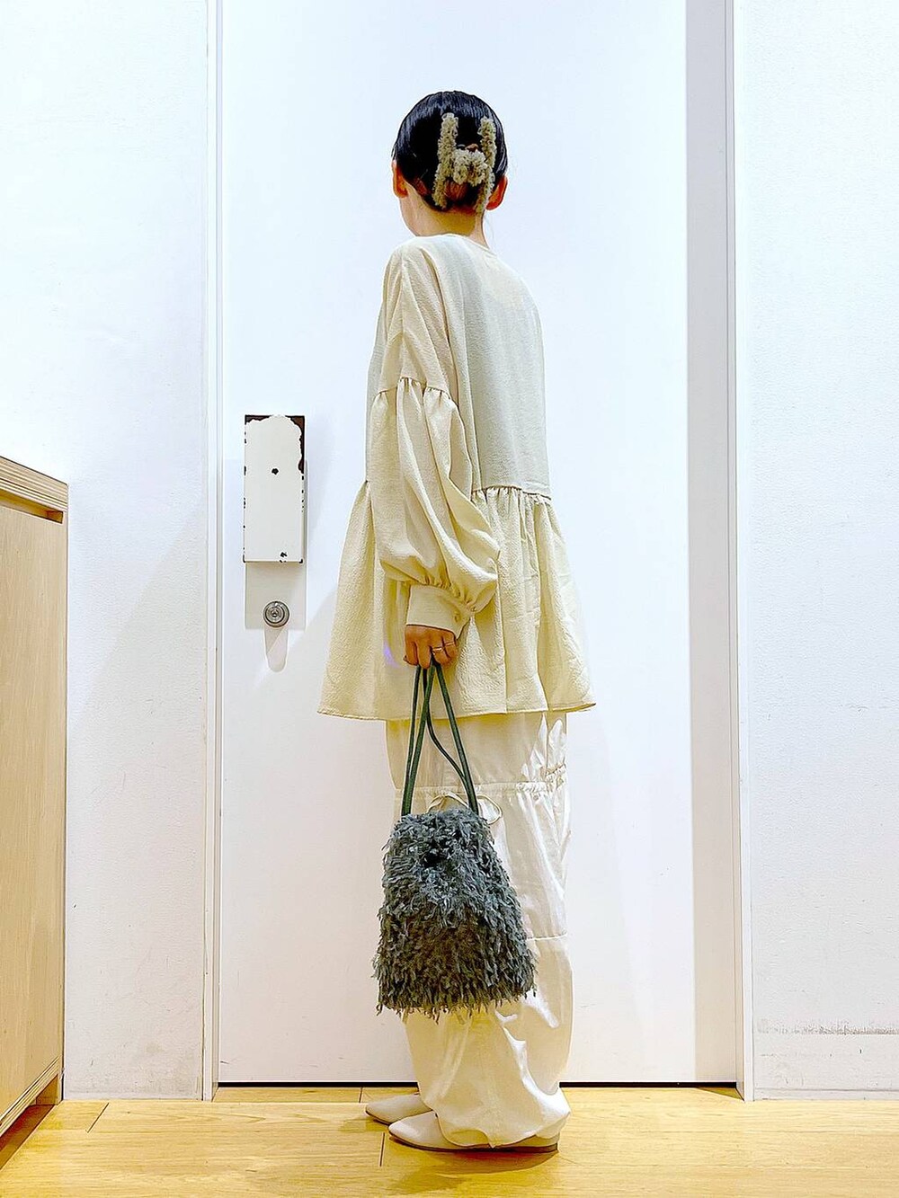 グリーン系のショルダーバッグ、ホワイト系のパンプス、ホワイト系のその他パンツを着用したレディースの秋コーディネートの3枚目の写真