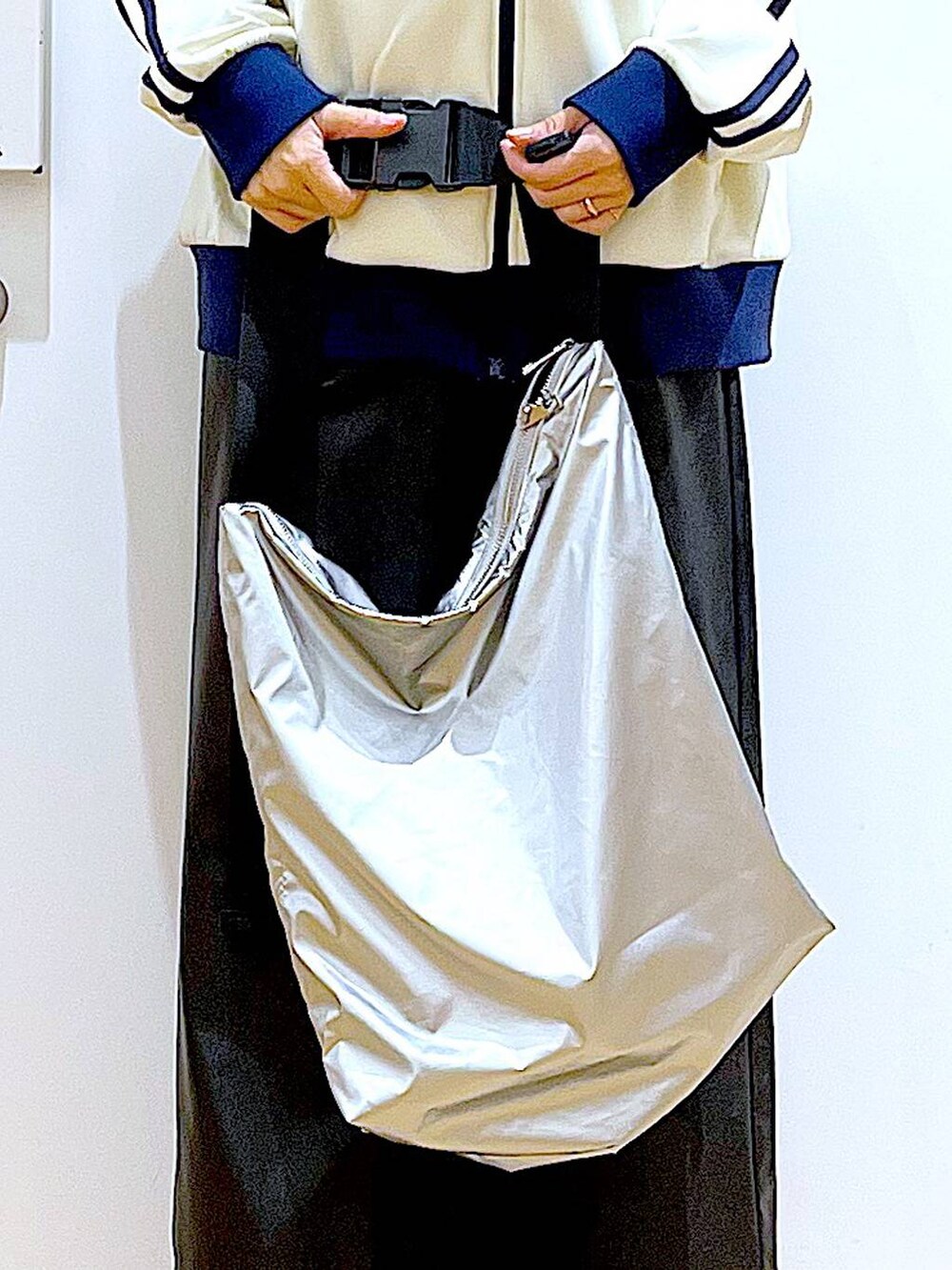 ブラック系のブーツ、ブラック系のスカート、シルバー系のショルダーバッグを着用したレディースの冬コーディネートの9枚目の写真