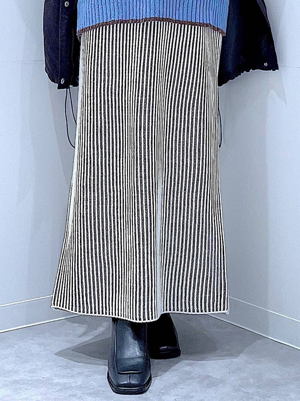 ブラック系のブルゾン、ベージュ系のスカート、ブラック系のブーツを着用したレディースの冬コーディネートの8枚目の写真