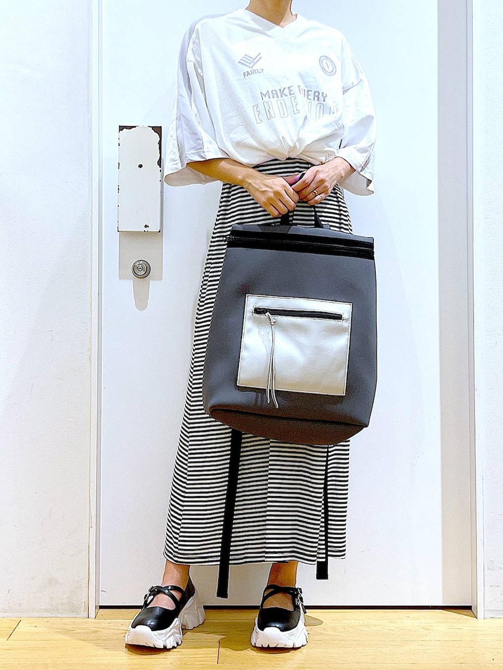 ブラック系のワンピース、ブラック系のスニーカー、グレー系のバックパック/リュックを着用したレディースの秋コーディネートの6枚目の写真