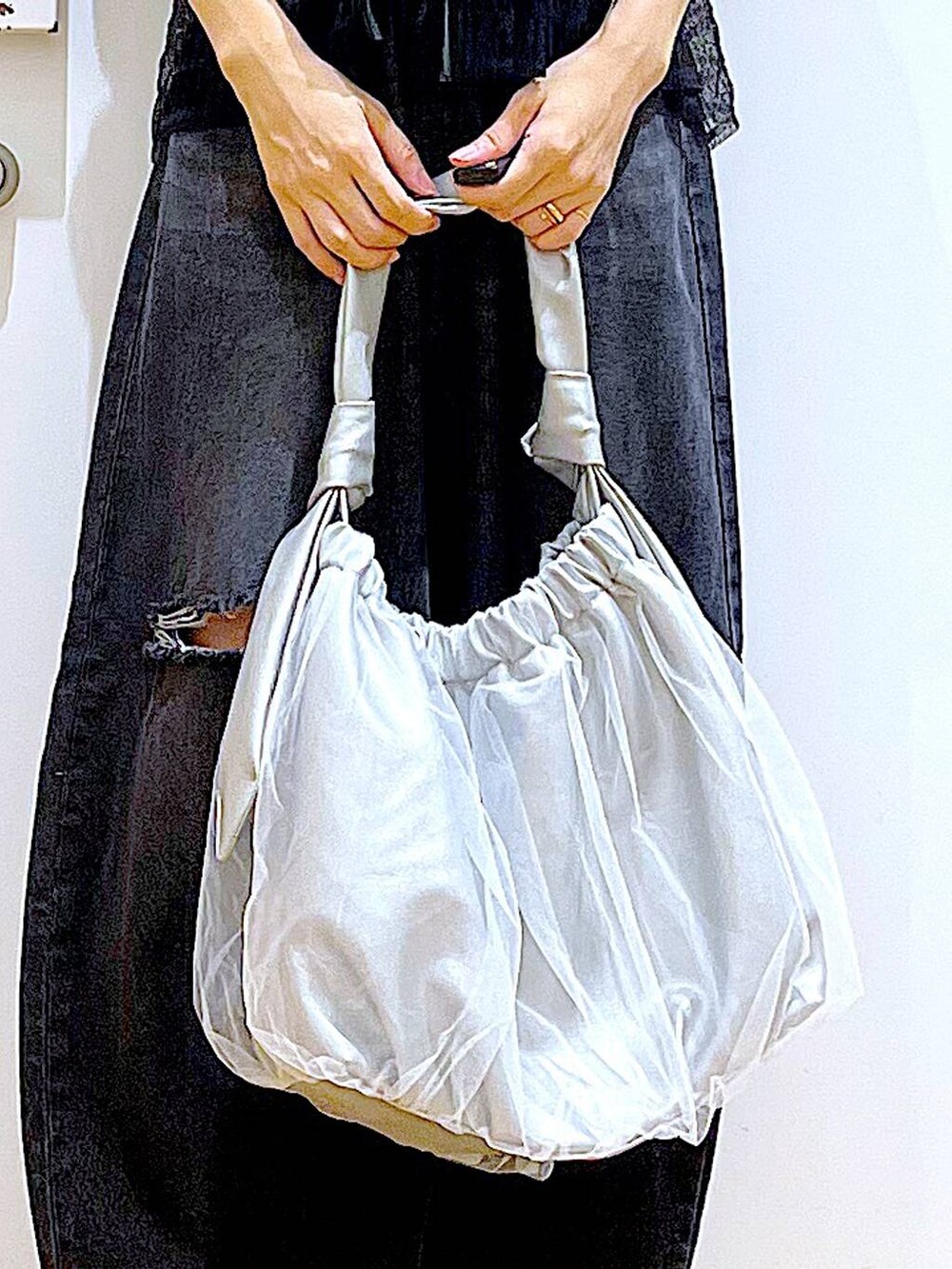 シルバー系のトートバッグ、ブラック系のデニムパンツ、ブラック系のカーディガン/ボレロを着用したレディースの秋コーディネートの9枚目の写真