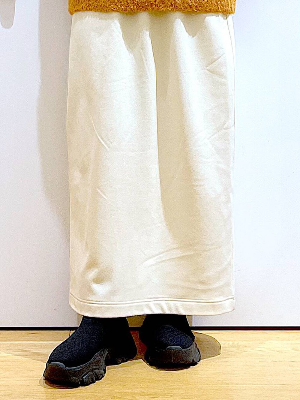 ブラック系のショルダーバッグ、ブラック系のブーツ、オレンジ系のニット/セーターを着用したレディースの冬コーディネートの8枚目の写真