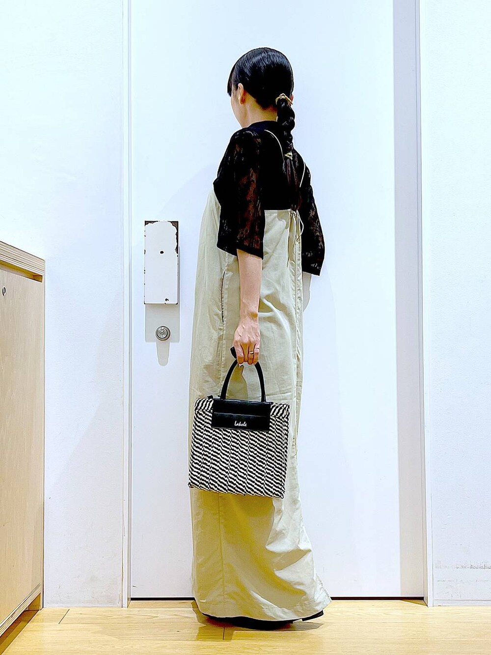 ベージュ系のワンピース、ブラック系のシャツ/ブラウス、ブラック系のパンプスを着用したレディースの春コーディネートの3枚目の写真