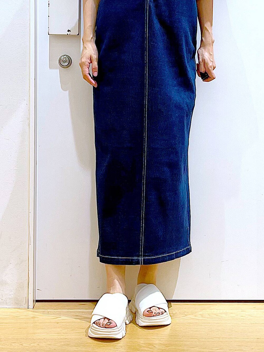 ブルー系のジャンパースカート、ホワイト系のショルダーバッグ、ホワイト系のサンダルを着用したレディースの夏コーディネートの8枚目の写真