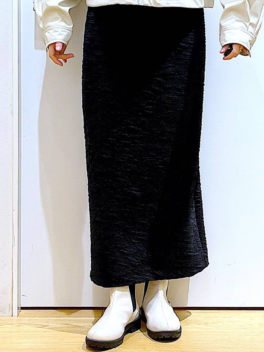 ブラック系のスカート、ベージュ系のブルゾン、ベージュ系のブーツを着用したレディースの春コーディネートの8枚目の写真