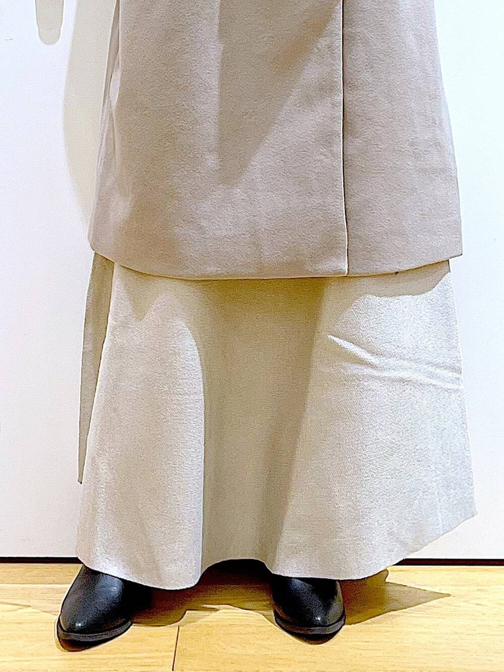 グレー系のステンカラーコート、ホワイト系のショルダーバッグ、グレー系のスカートを着用したレディースの冬コーディネートの8枚目の写真