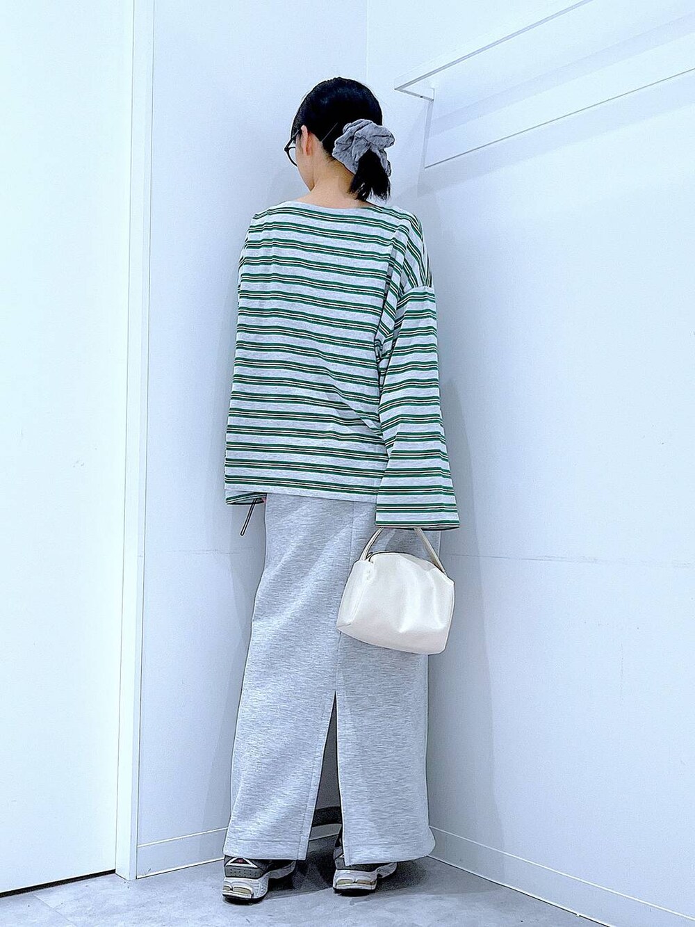 ホワイト系のショルダーバッグ、グレー系のスカート、グレー系のTシャツ/カットソーを着用したレディースの春コーディネートの5枚目の写真