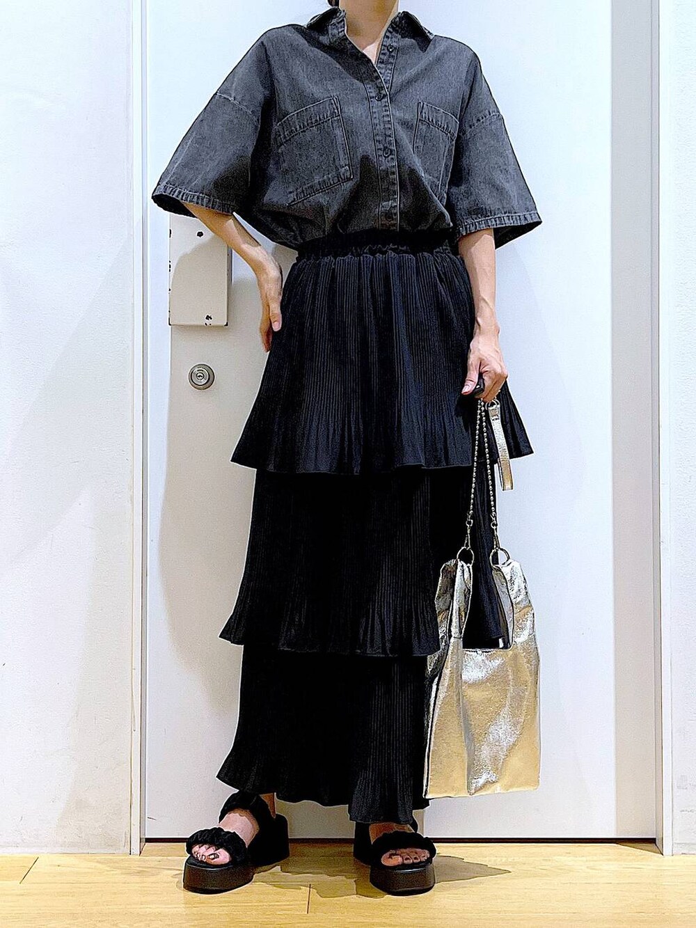 シルバー系のショルダーバッグ、ブラック系のスカート、ブラック系のサンダルを着用したレディースの夏コーディネートの6枚目の写真