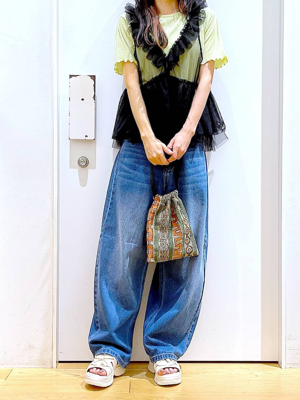 ブラウン系のショルダーバッグ、ホワイト系のサンダル、ブルー系のデニムパンツを着用したレディースの夏コーディネートの7枚目の写真