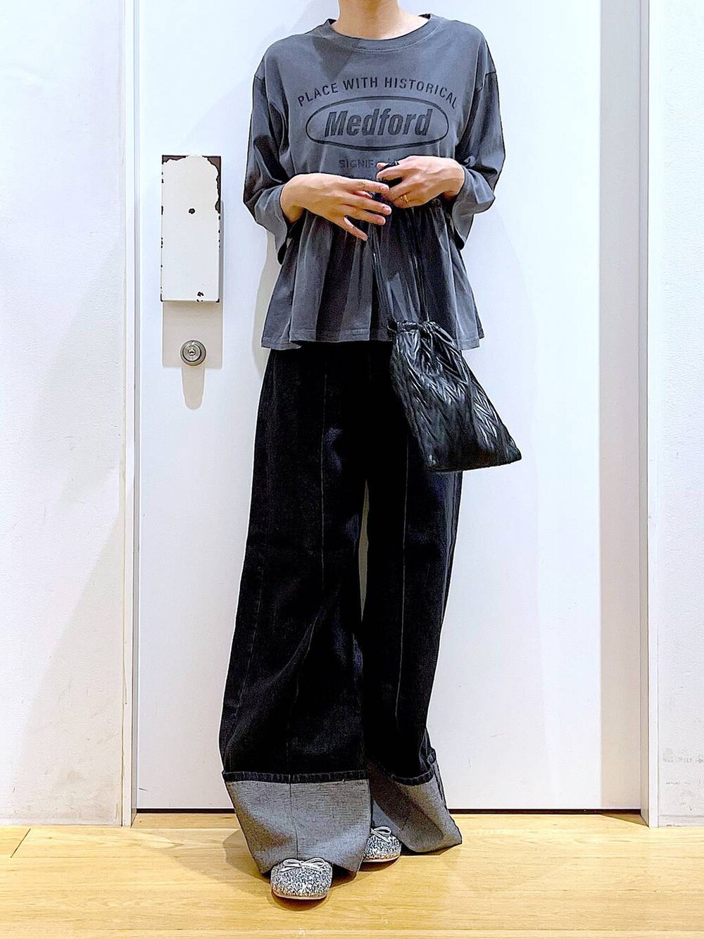 ブラック系のショルダーバッグ、シルバー系のパンプス、ブラック系のデニムパンツを着用したレディースの秋コーディネートの6枚目の写真