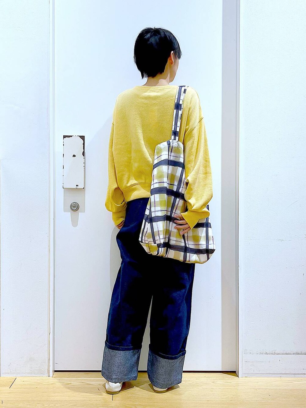 ホワイト系のパンプス、ブルー系のデニムパンツ、その他のトートバッグを着用したレディースの冬コーディネートの5枚目の写真