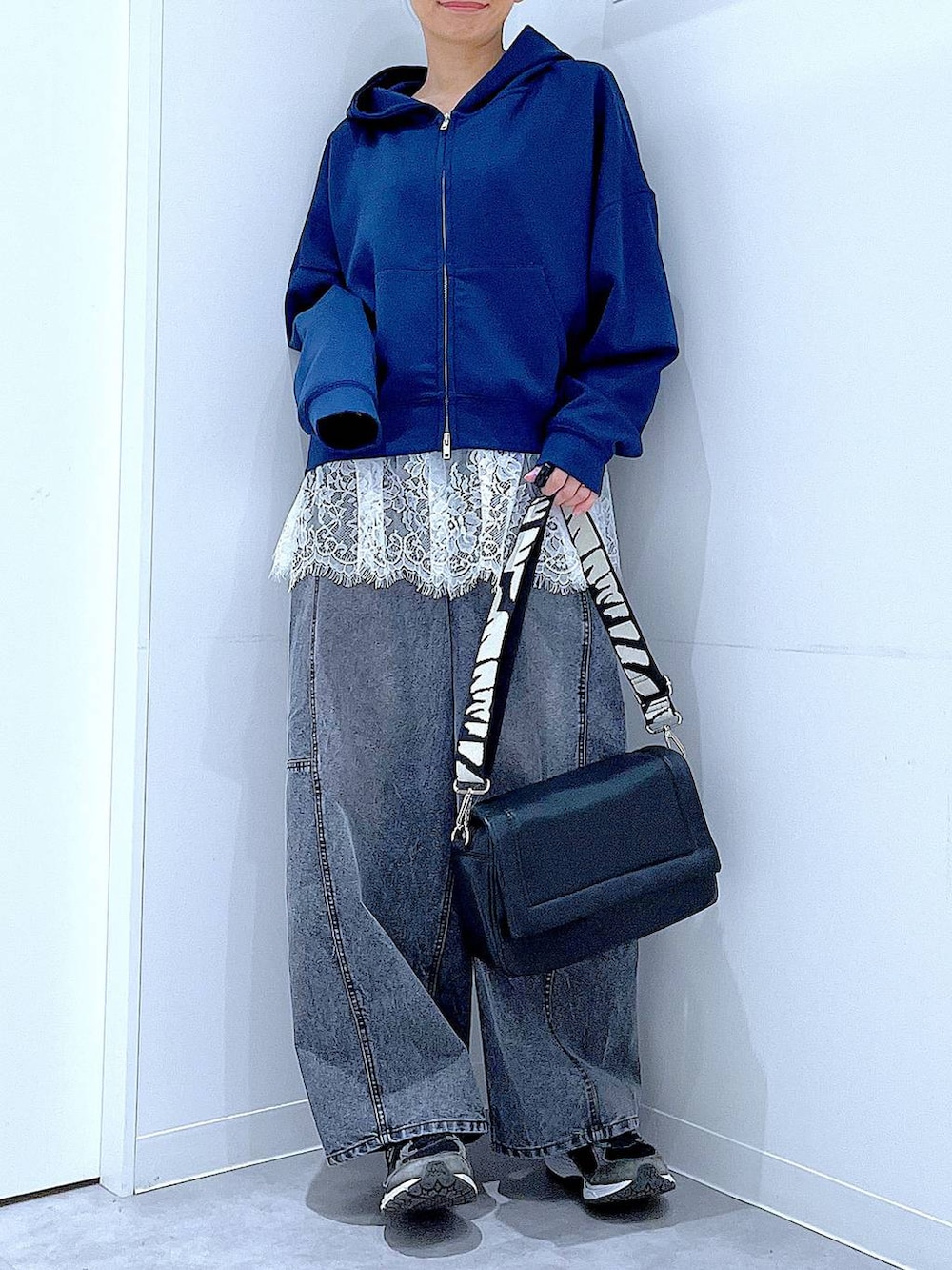 ブラック系のショルダーバッグ、ホワイト系のTシャツ/カットソー、ブラック系のデニムパンツを着用したレディースの春コーディネートの6枚目の写真