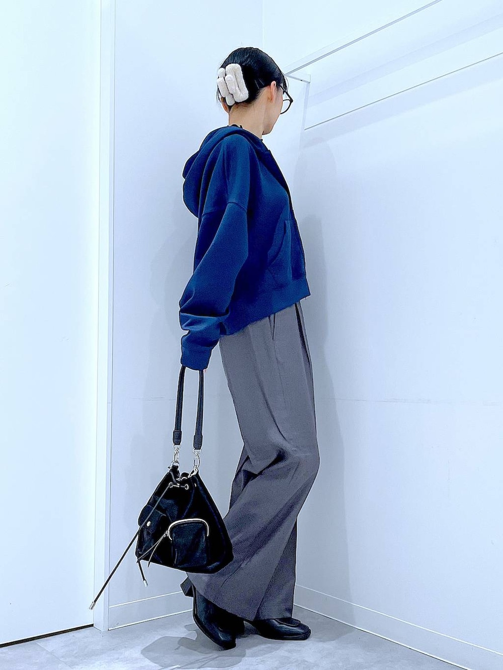 ブラック系のショルダーバッグ、ブラック系のブーツ、グレー系のスラックスを着用したレディースの冬コーディネートの4枚目の写真