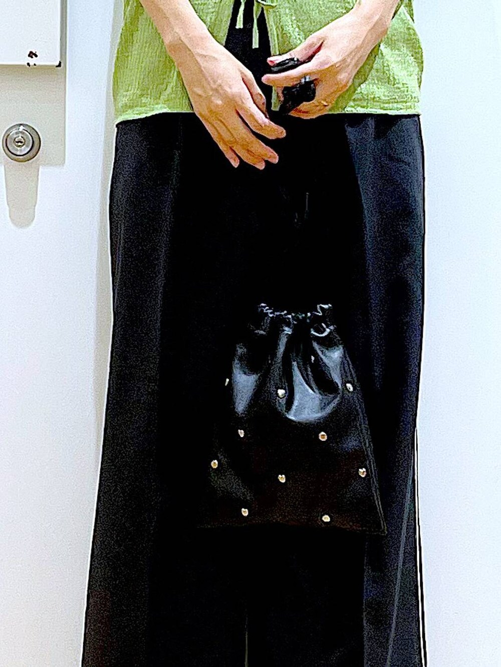 ブラック系のサンダル、ホワイト系のニット/セーター、ブラック系のショルダーバッグを着用したレディースの夏コーディネートの9枚目の写真