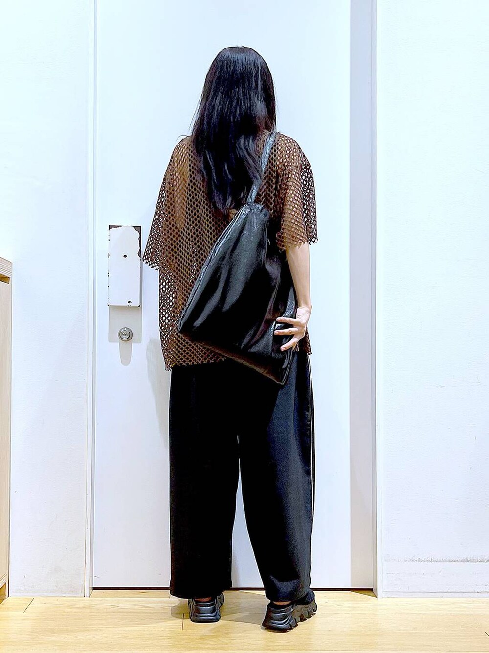 ブラック系のトートバッグ、ブラック系のニット/セーター、ブラック系のサンダルを着用したレディースの夏コーディネートの5枚目の写真