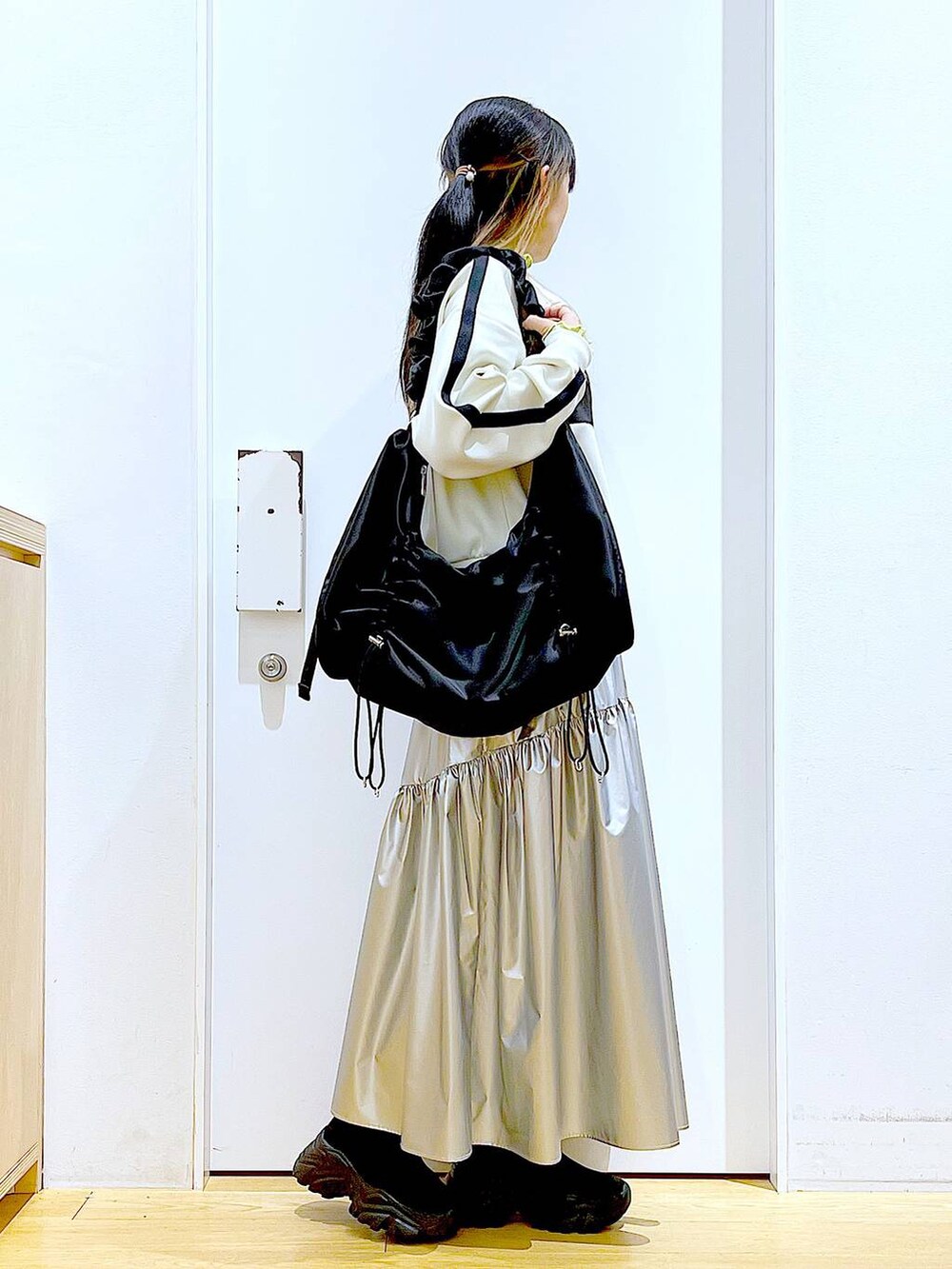 グリーン系のTシャツ/カットソー、ベージュ系のブルゾン、ブラック系のスニーカーを着用したレディースの春コーディネートの4枚目の写真