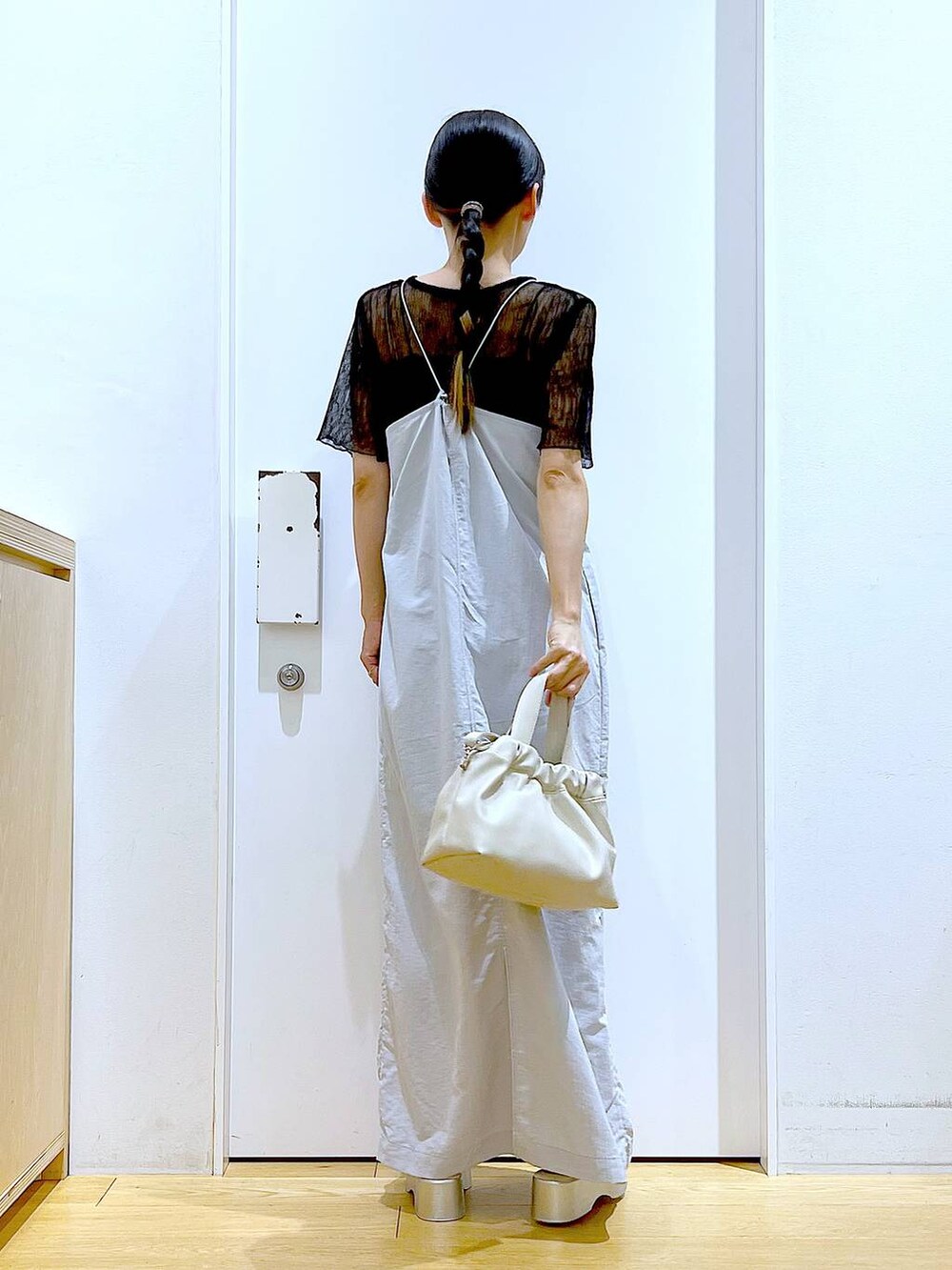 グレー系のワンピース、ホワイト系のショルダーバッグ、シルバー系のサンダルを着用したレディースの夏コーディネートの5枚目の写真