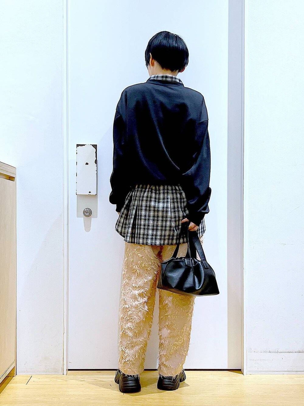 ブラック系のブーツ、ブラック系のTシャツ/カットソー、ブラック系のショルダーバッグを着用したレディースの冬コーディネートの5枚目の写真