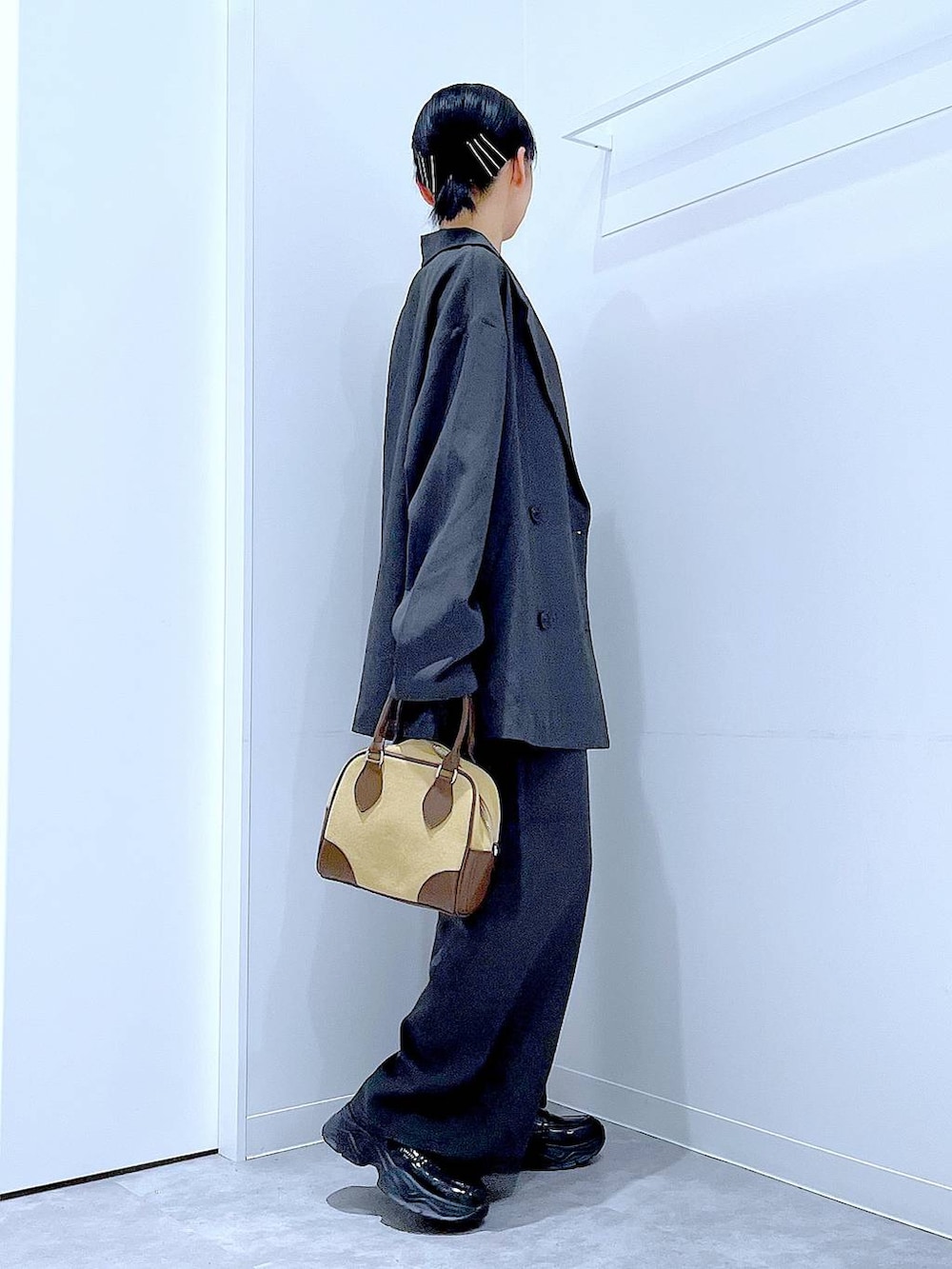 ブラック系のローファー、ベージュ系のハンドバッグ、グレー系のテーラードジャケットを着用したレディースの秋コーディネートの4枚目の写真