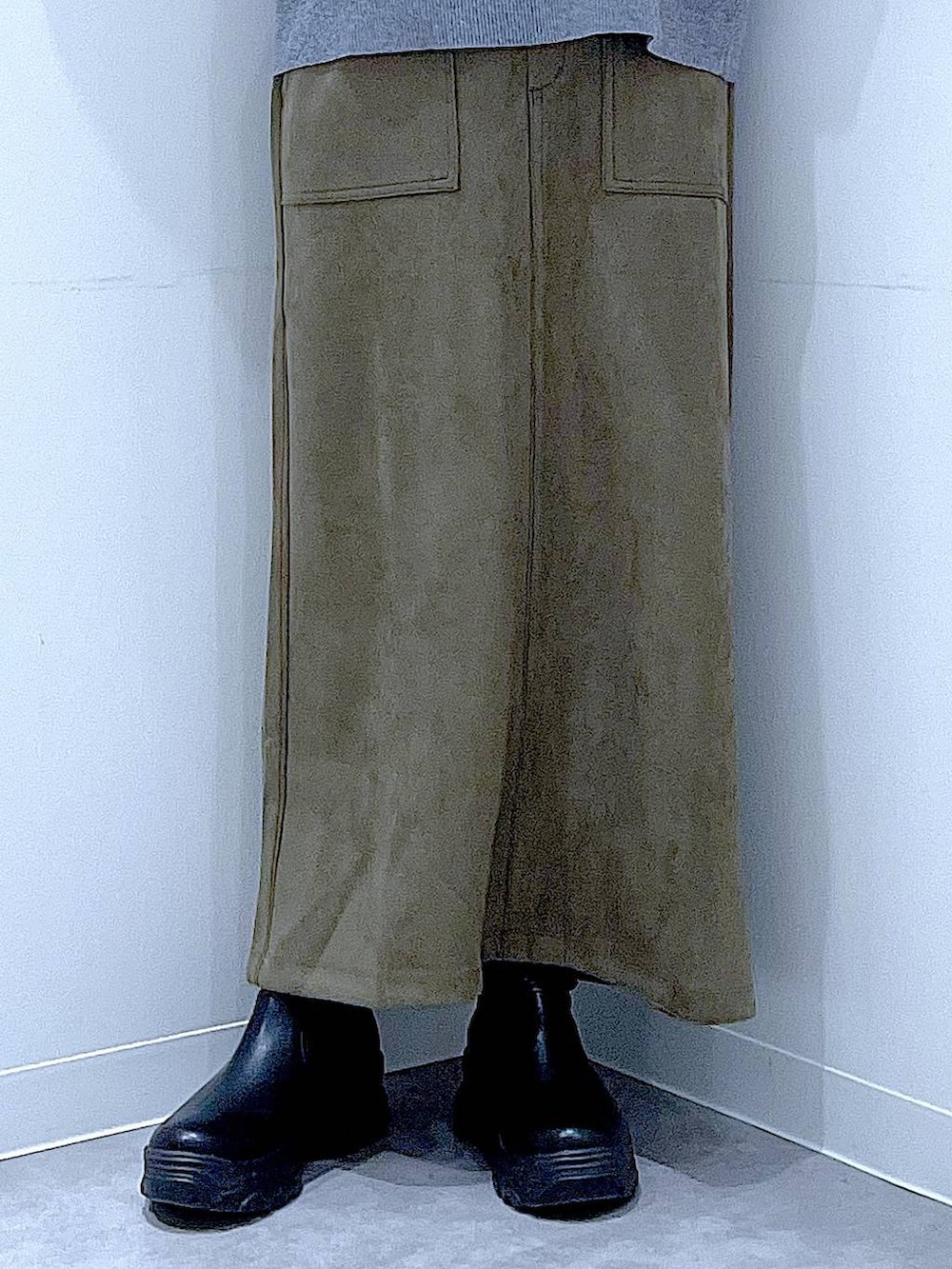 ブラック系のショルダーバッグ、ブラック系のブーツ、グリーン系のスカートを着用したレディースの冬コーディネートの8枚目の写真