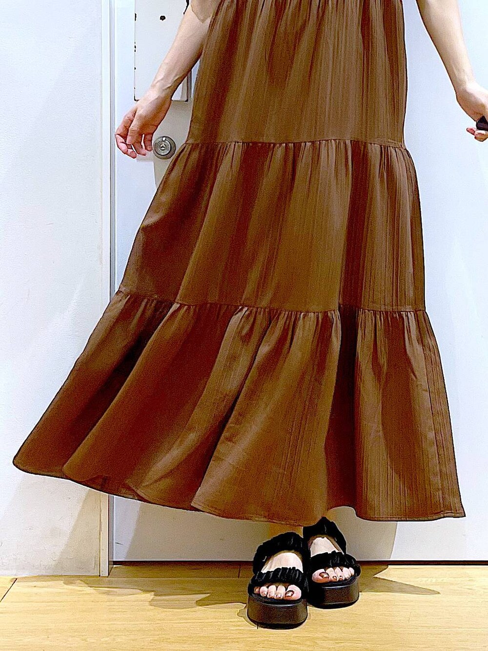 ブラック系のサンダル、ブラック系のショルダーバッグ、ベージュ系のワンピースを着用したレディースの夏コーディネートの8枚目の写真