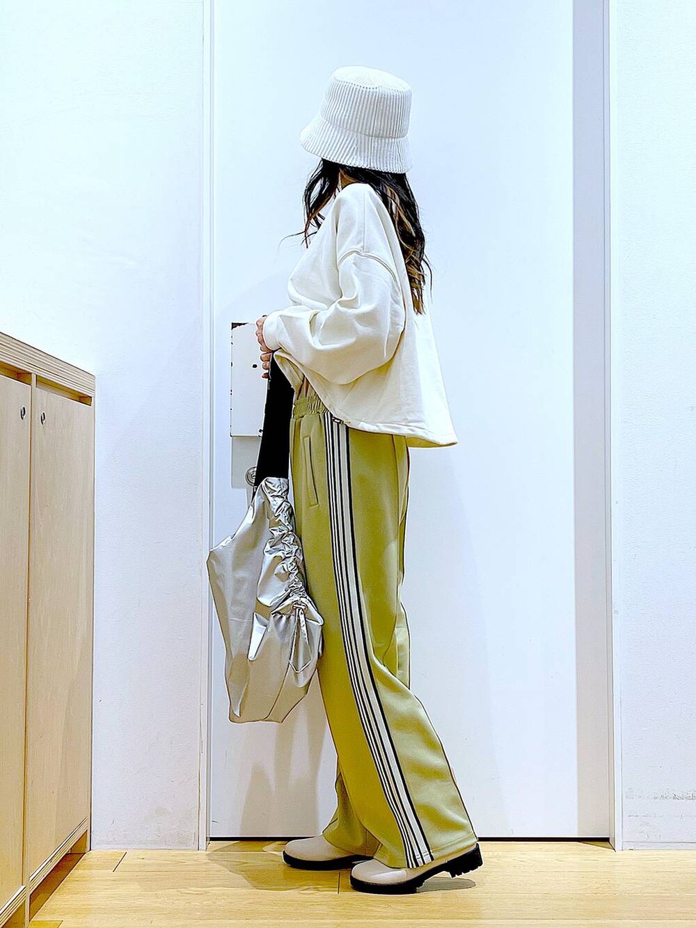 ホワイト系のスウェット、ベージュ系のブーツ、シルバー系のショルダーバッグを着用したレディースの春コーディネートの3枚目の写真