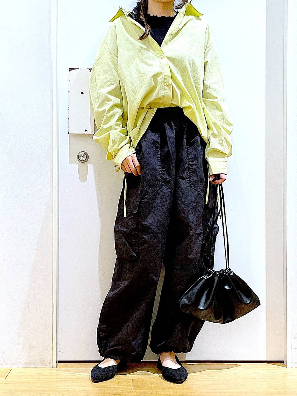 グリーン系のシャツ/ブラウス、ブラック系のショルダーバッグ、ブラック系のパンプスを着用したレディースの春コーディネートの6枚目の写真