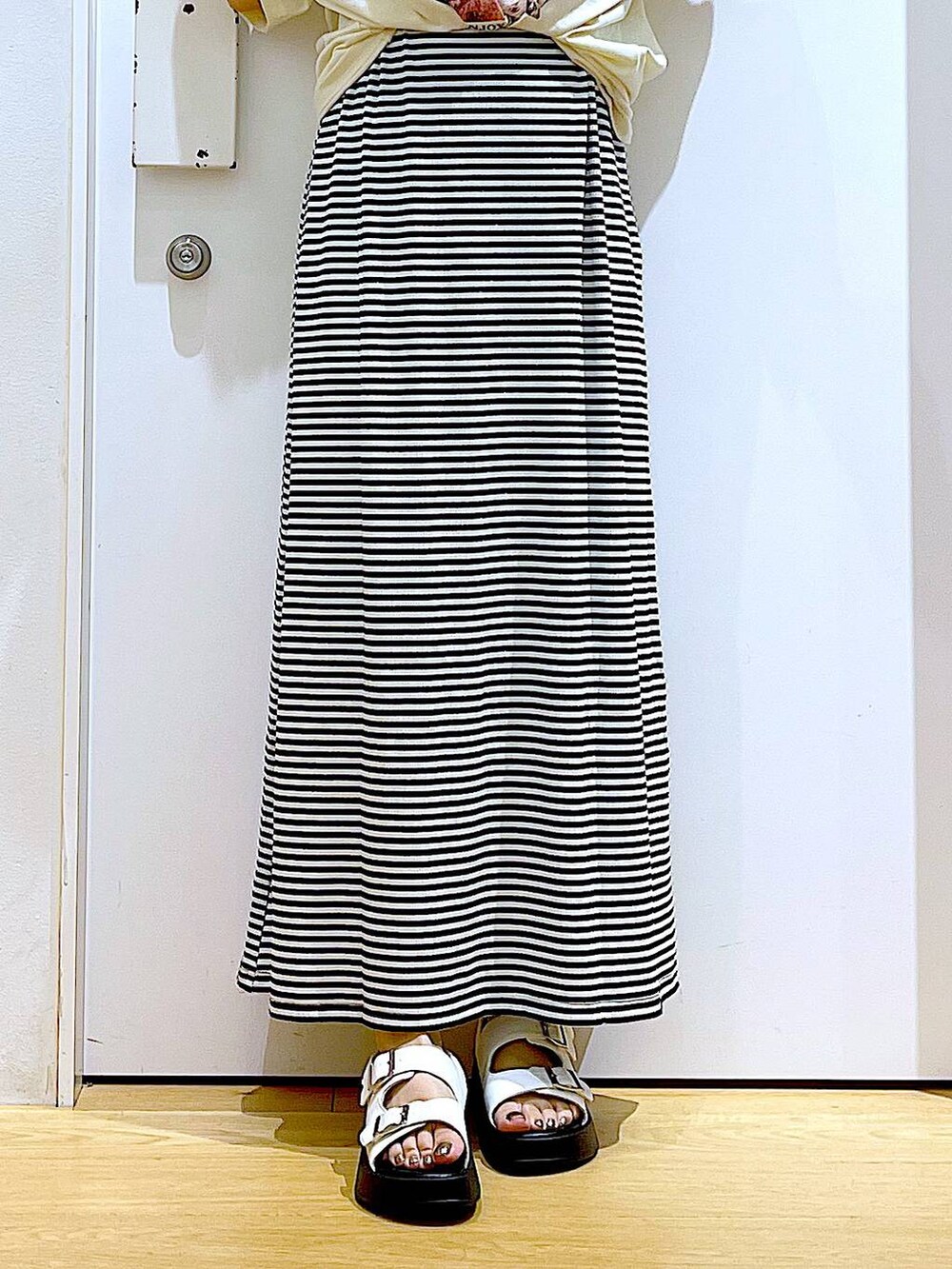 ホワイト系のサンダル、ブルー系のトートバッグ、ブラック系のワンピースを着用したレディースの夏コーディネートの8枚目の写真