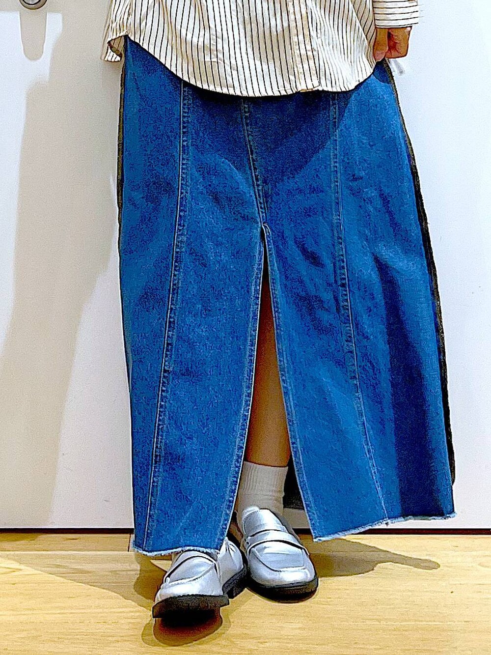 ベージュ系のショルダーバッグ、シルバー系のローファー、ブルー系のデニムスカートを着用したレディースの秋コーディネートの8枚目の写真