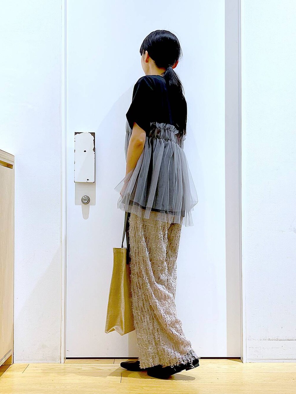 ブラック系のTシャツ/カットソー、ブラック系のパンプス、グレー系のトートバッグを着用したレディースの夏コーディネートの3枚目の写真