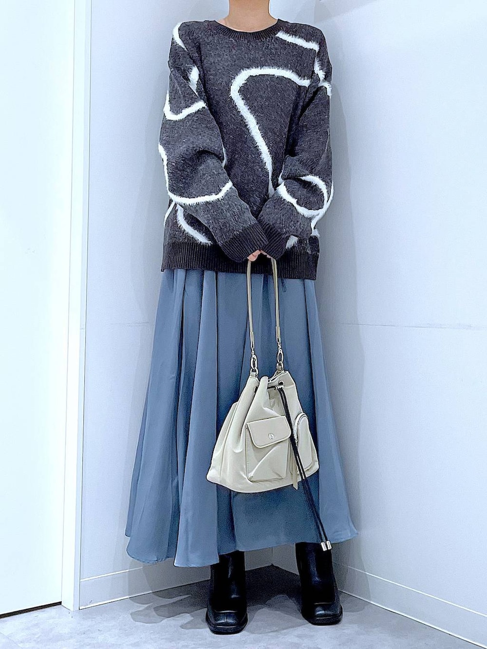 ブラック系のブーツ、グレー系のニット/セーター、ブラウン系のバレッタ/ヘアクリップを着用したレディースの冬コーディネートの6枚目の写真