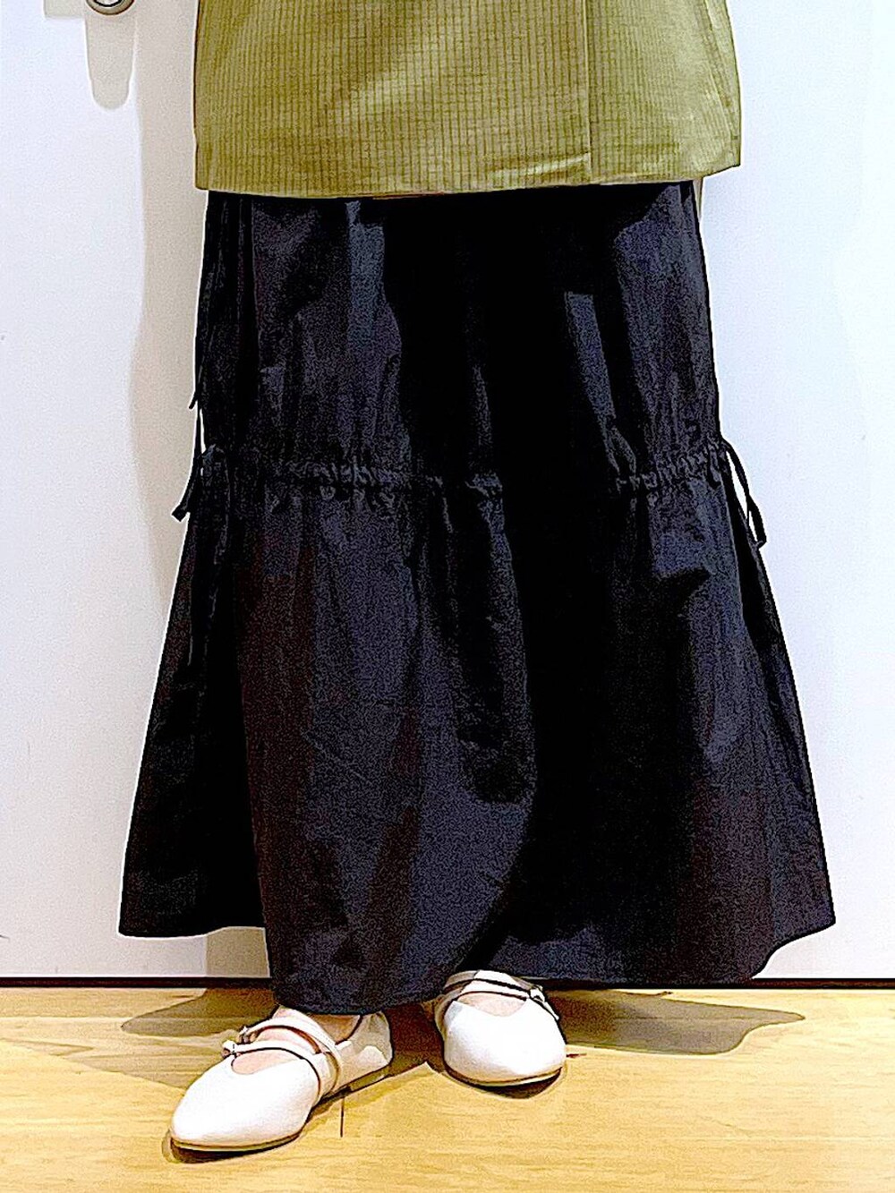 ブラック系のショルダーバッグ、ホワイト系のパンプス、ホワイト系のTシャツ/カットソーを着用したレディースの秋コーディネートの8枚目の写真