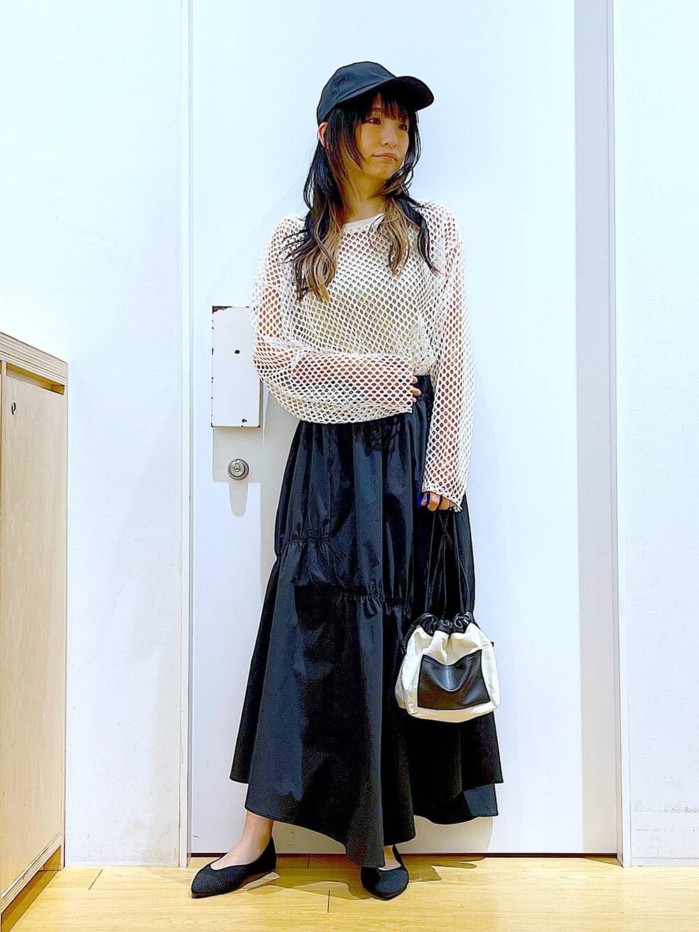 ホワイト系のTシャツ/カットソー、ホワイト系のショルダーバッグ、イエロー系のニット/セーターを着用したレディースの春コーディネートの2枚目の写真